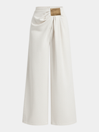 Ruched wide-leg jeans in cream denim with asymmetric design and gold buckle draped waist.