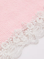 Short sleeve ribbed cardigan with white lace trim, floral and bow patterns along edges.
