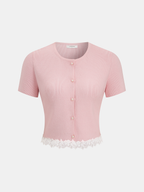 Short sleeve ribbed cardigan with pearl buttons and delicate white lace trim at hem.