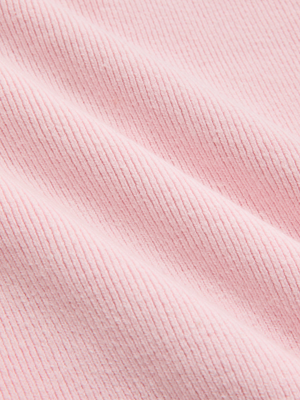 Short sleeve cardigan made of soft, light pink ribbed fabric with gentle folds and lace trim.