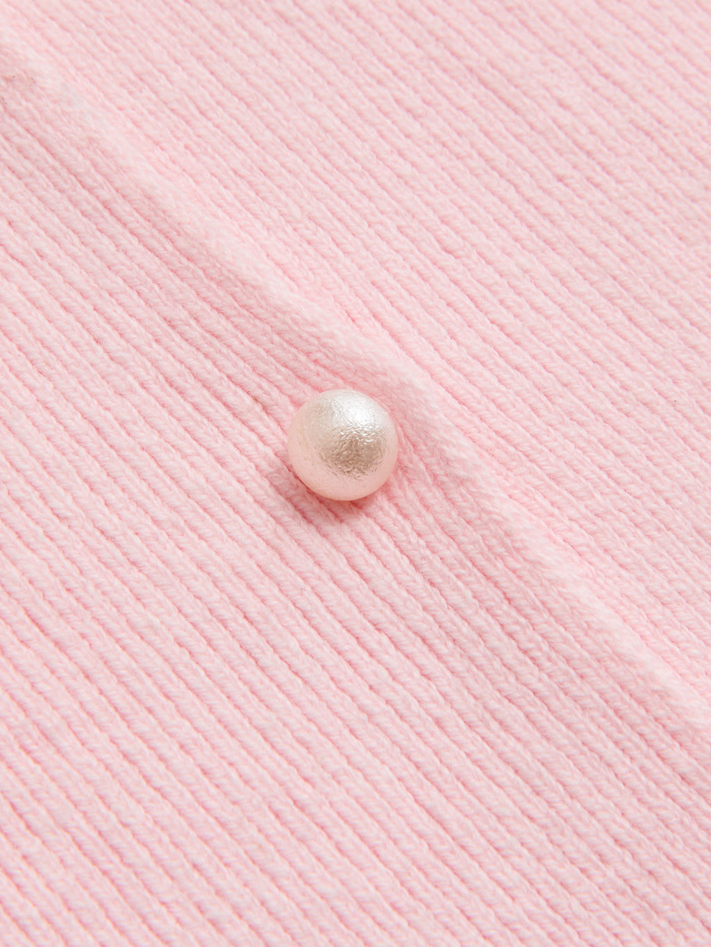 Light pink ribbed cardigan with lace trim, round pearl button, and visible vertical texture.