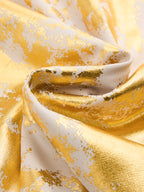 White slip dress with shiny gold foil patterns, visible folds, and a textured finish.