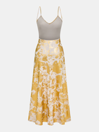 Metallic slip dress with V-neck, grey bodice, gold and white abstract flared skirt.