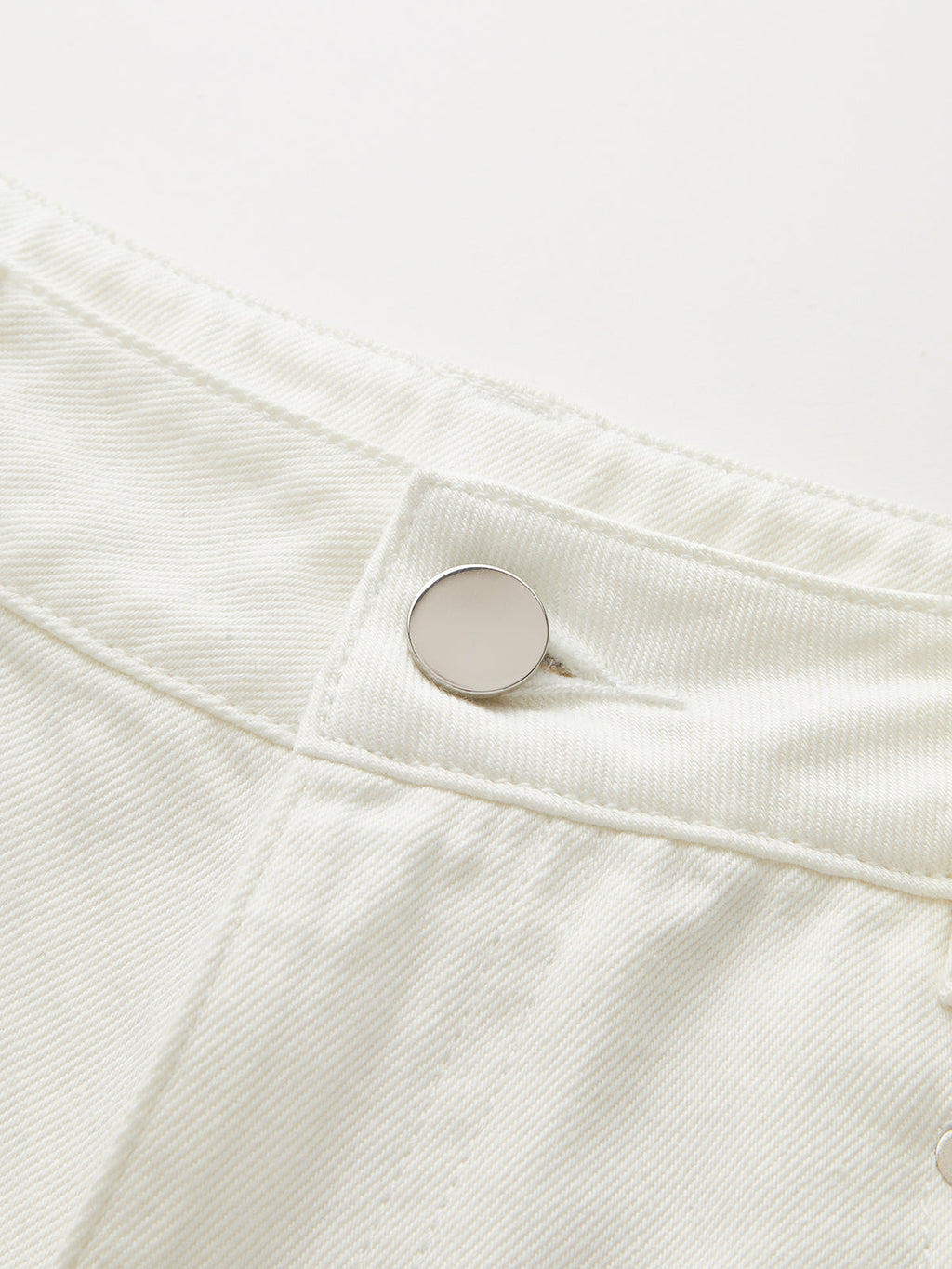 Mid-rise wide-leg jeans with soft denim, metal button, visible stitching, and Tencel cotton blend.