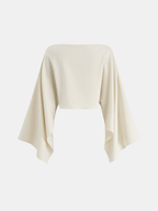 A cream linen crop top with a slim fit, off-the-shoulder cut, and bold cape sleeves.