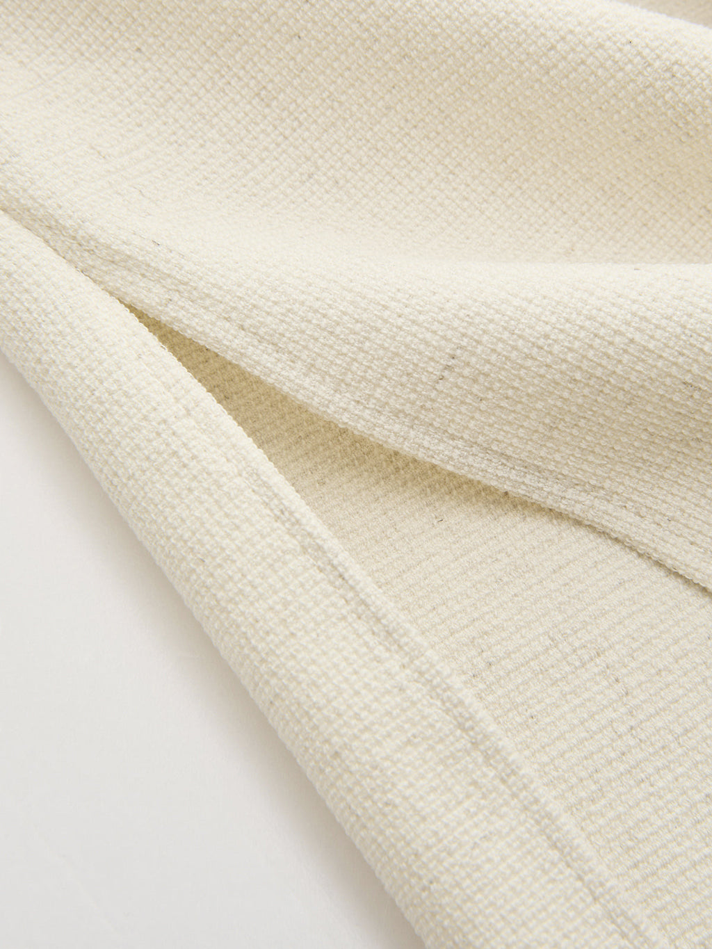 Off-white linen crop top with bold sleeves, subtle square pattern, and textured finish.