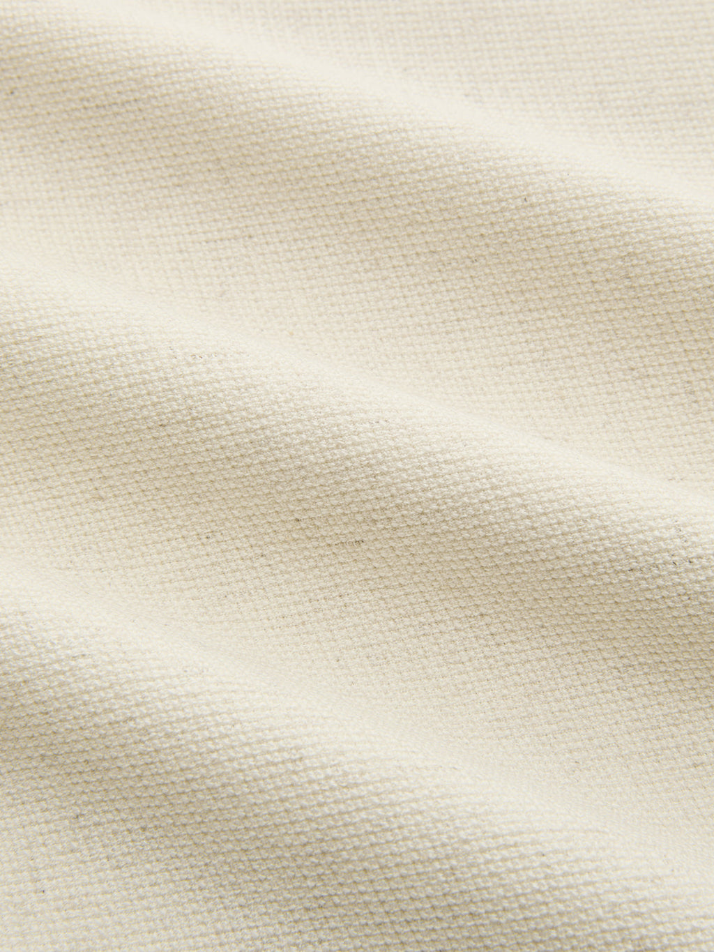 Linen crop top with bold sleeve accents, off-white fabric showing textured weave and soft folds.