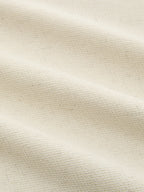 Linen crop top with bold sleeve accents, off-white fabric showing textured weave and soft folds.