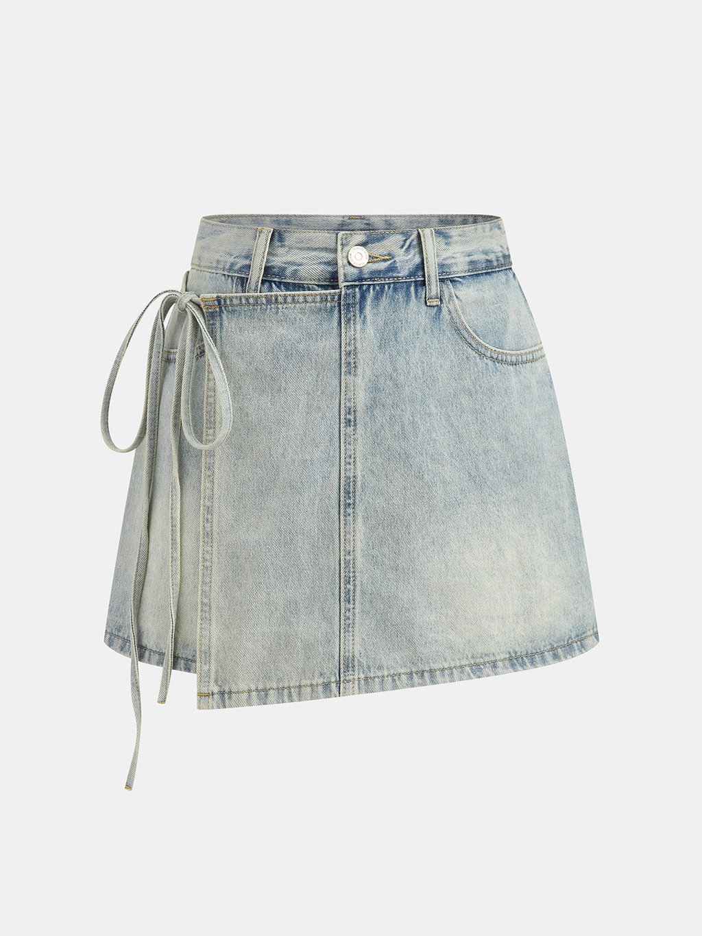 A denim mini skort with crossover front, side tie, asymmetric hem, faded wash, gold stitching.