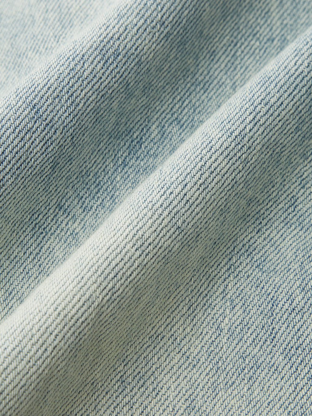 Denim Crossover Skort with mini length, woven texture, diagonal lines, and soft folds.