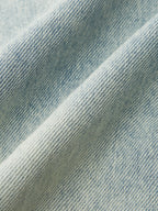 Denim Crossover Skort with mini length, woven texture, diagonal lines, and soft folds.