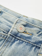 Denim crossover skort with mini length, classic metal button, visible stitching, and coin pocket.