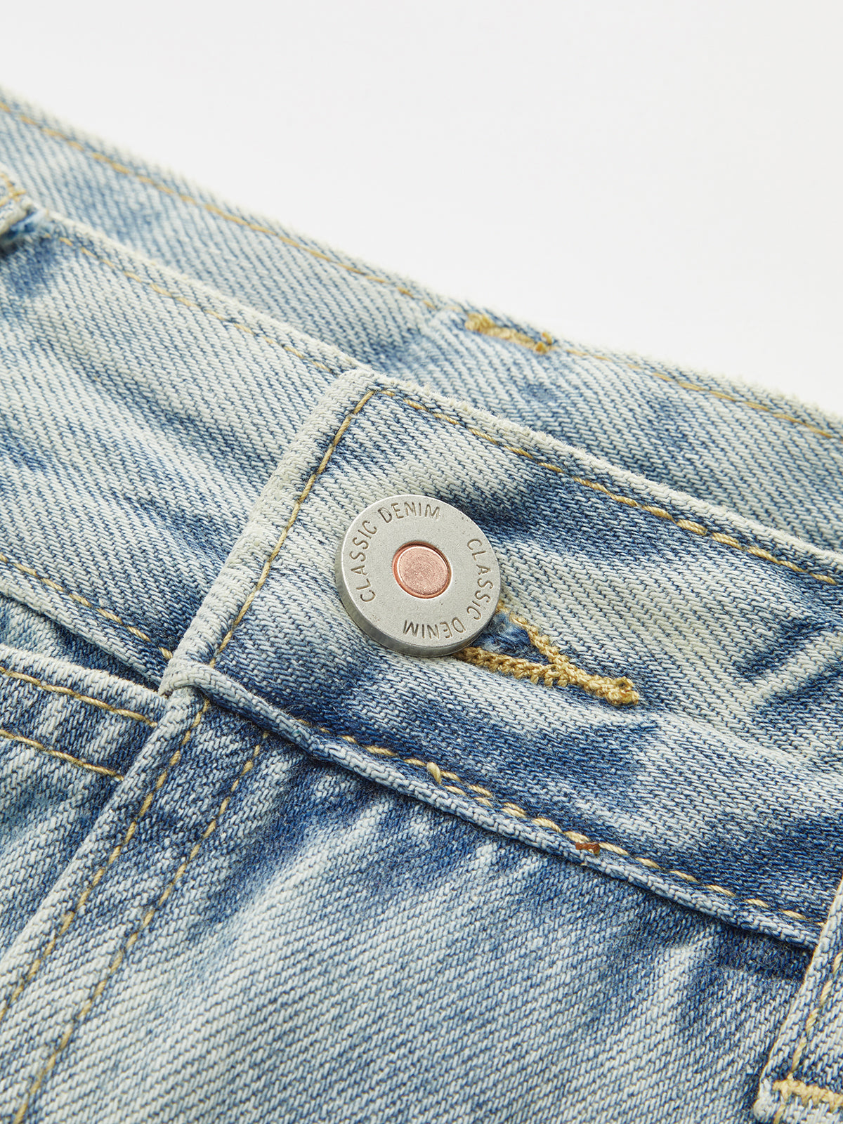 Denim crossover skort with mini length, classic metal button, visible stitching, and coin pocket.