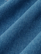 Blue denim halter dress with button-front and maxi design, detailed weave, soft shadows.