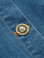 Denim halter maxi dress with gold lion button, orange-brown stitching, and blue cotton-blend.