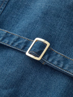 Denim halter maxi dress with button front, gold buckle strap, and textured stitching.