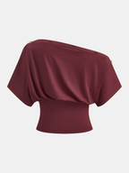 One-shoulder top with unique button details, featuring a sleek and contemporary design.