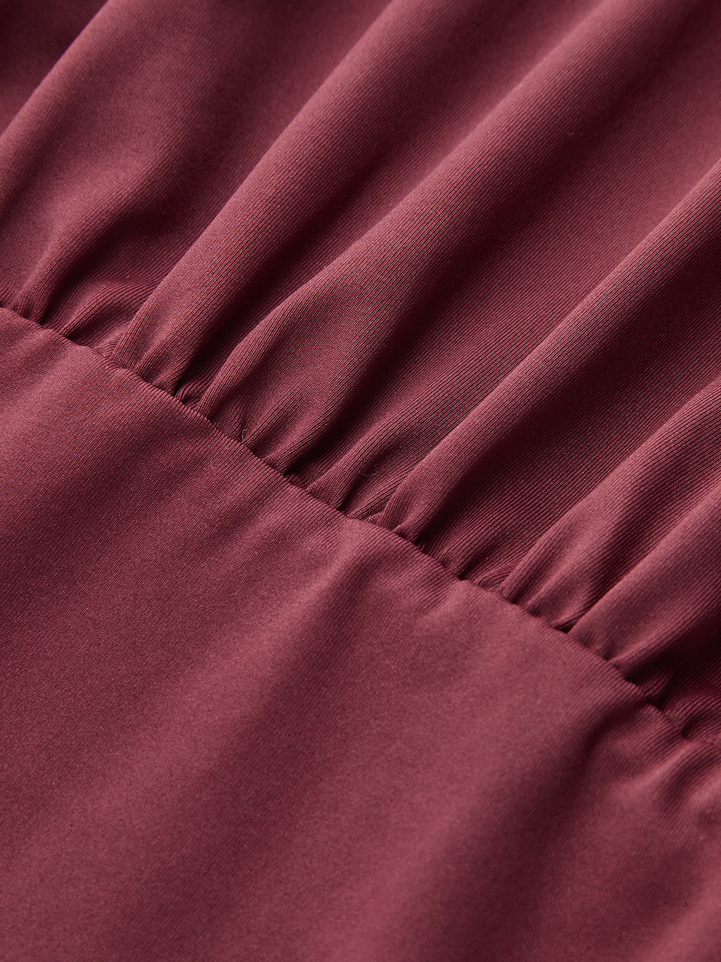 Maroon one-shoulder top with slim fit and distinctive button accents for added dimension.