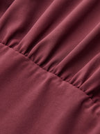 Maroon one-shoulder top with slim fit and distinctive button accents for added dimension.