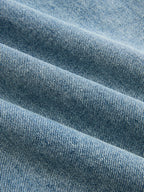 Light blue denim jeans with diagonal twill weave, soft folds, and subtle shaded details.
