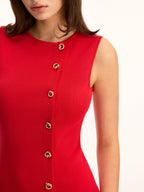 Sleeveless red knit sheath dress, mini length, slim fit, gold buttons diagonally across front.