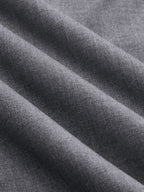 Soft gray wrap-style wide-leg trousers with fine weave and diagonal folds, featuring buckle accents.