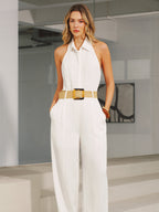A white halter neck jumpsuit with collar, wide legs, and a beige belt.