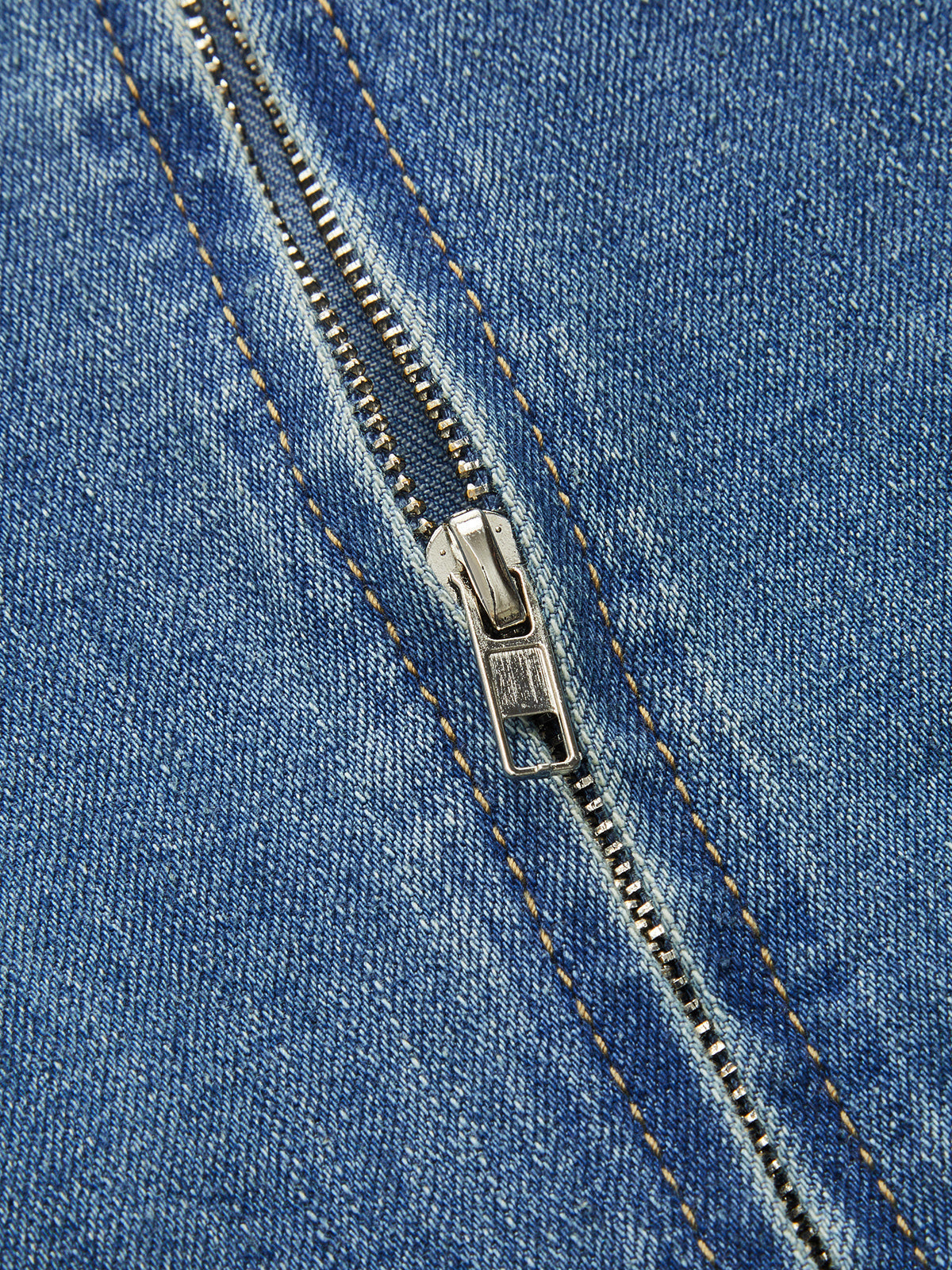 Close-up of a sleeveless denim midi dress with orange-stitched zipper, partially open teeth.