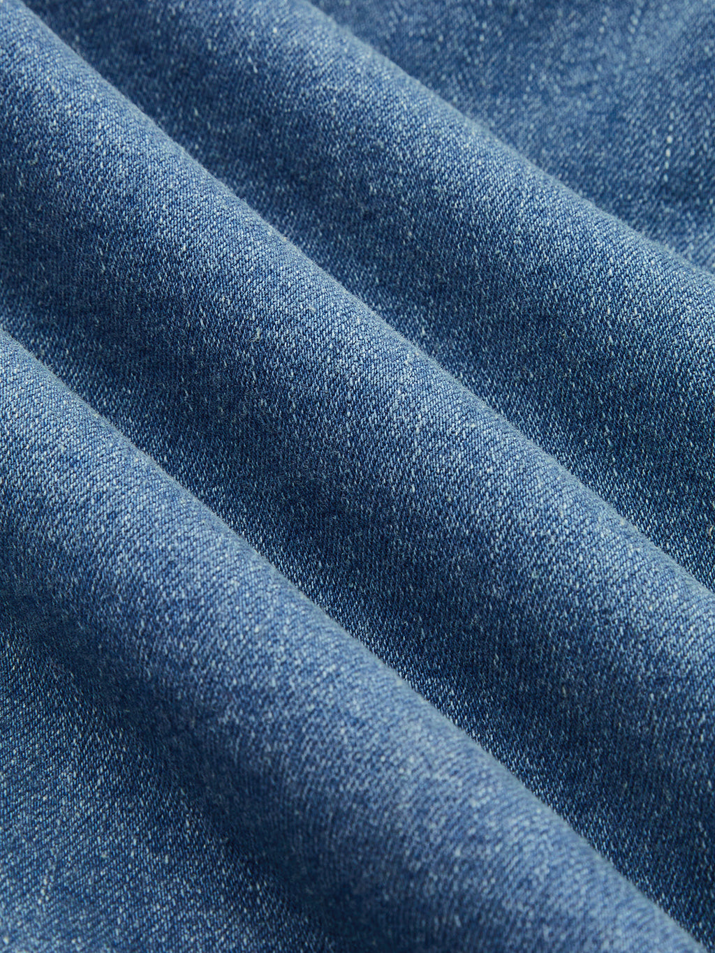 Blue cotton-blend denim midi dress with halter neckline, visible weave and soft diagonal folds.