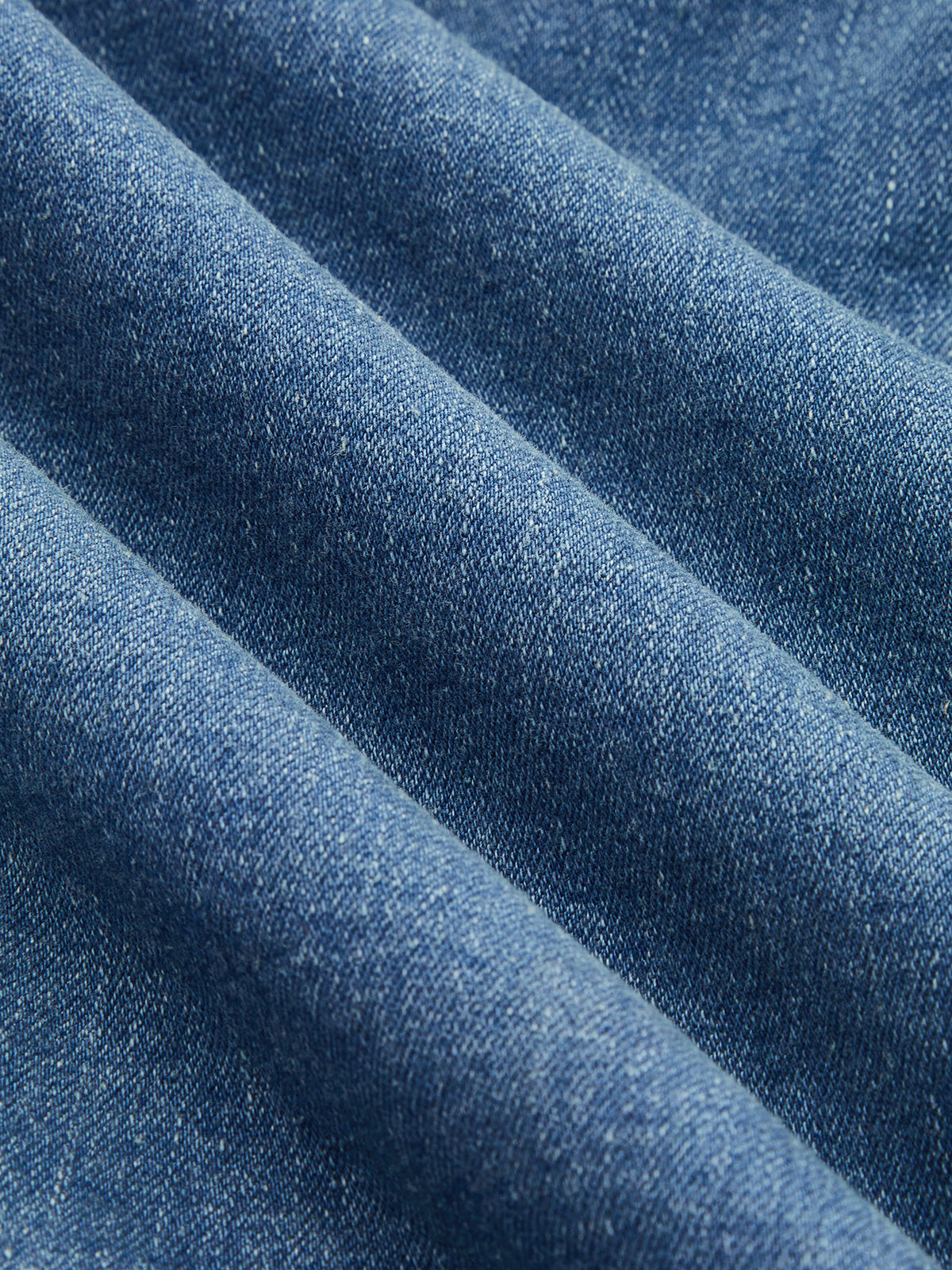 Blue cotton-blend denim midi dress with halter neckline, visible weave and soft diagonal folds.