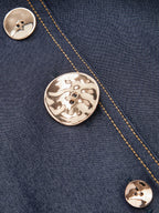 Dark blue denim maxi dress with v-neckline, gold buttons, and yellow contrast stitching.