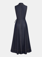 Sleeveless dark blue denim maxi dress with tan stitching, button details, and matching tie belt.