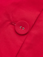 Close-up of detailed stitching and round red button on LA FINE FLEUR maxi dress.