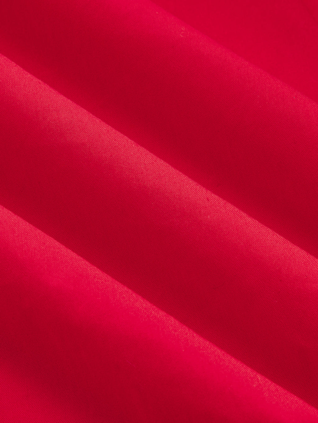 Close-up of a cotton blend maxi dress, bright red with button-front, soft folds, textured fabric.
