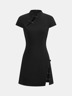 Short-sleeved black mini dress with mandarin collar, traditional frog buttons, and hem slit.