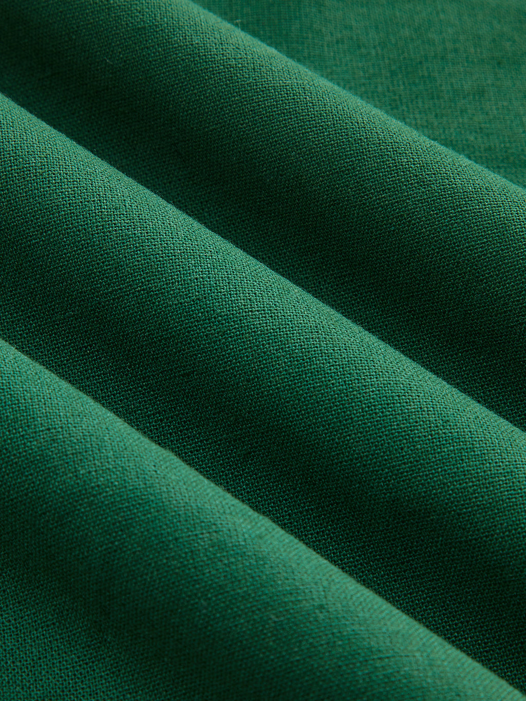Teal green linen-blend mini dress with ruching, textured fabric, and four diagonal folds.