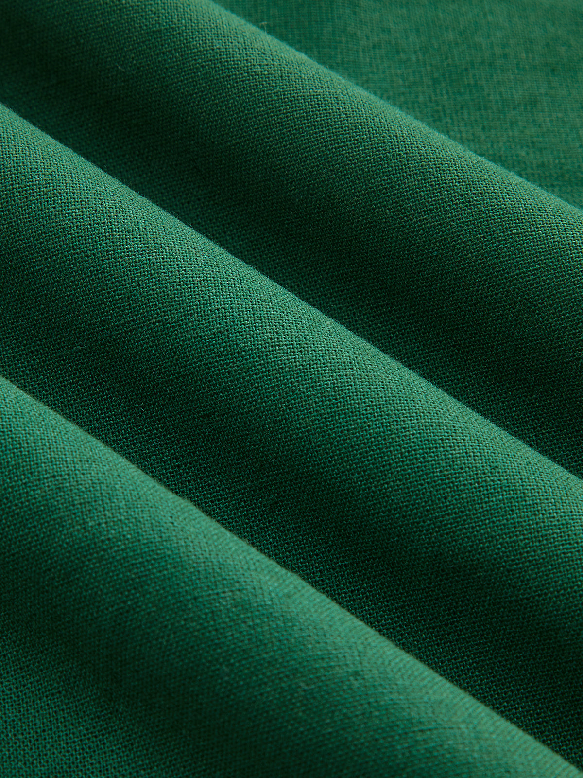 Teal green linen-blend mini dress with ruching, textured fabric, and four diagonal folds.
