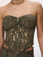 A strapless lace bustier top in a romantic style, designed as a corset.
