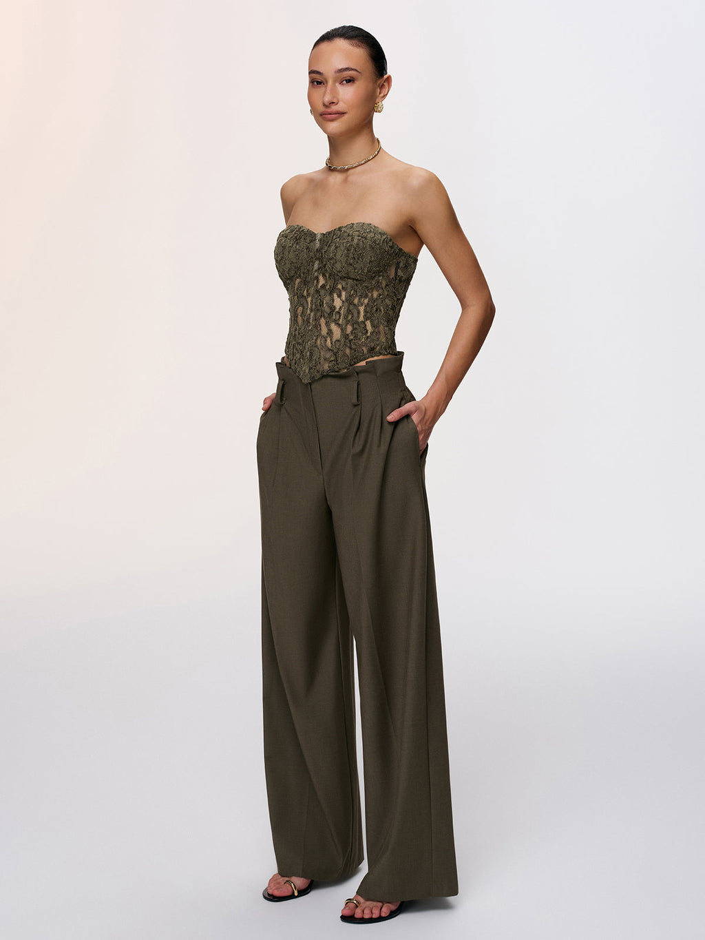 LA FINE FLEUR Romantic Lace Strapless Bustier Top with high-waisted wide-leg olive trousers.