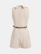A beige sleeveless blazer romper with pointed collar, back zipper, brown waist belt, tailored shorts.