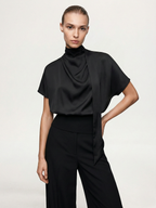 Satin mock neck blouse with elegant neck tie, paired with wide-leg black pants.