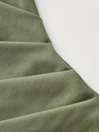 Olive green ribbed mock neck top with short sleeves, ruching, and diagonal textured seams.