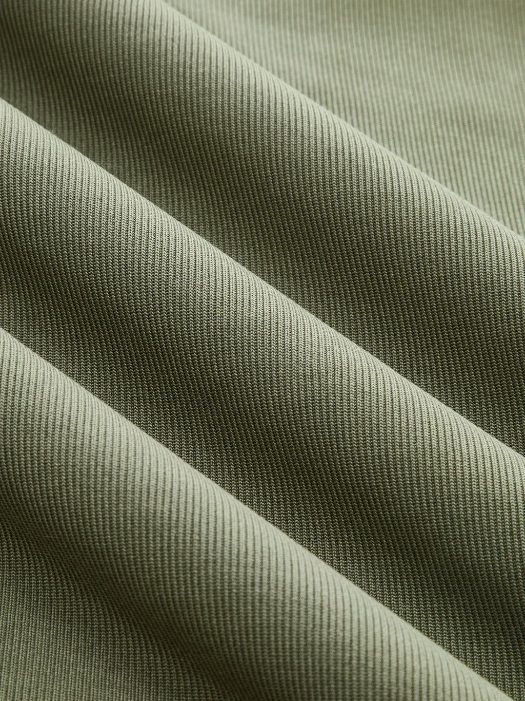 Olive green ribbed mock neck top with short sleeves, ruching, and diagonal textured ridges.