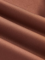 Brown satin cocktail dress with soft folds and sheen, showcasing its luxurious, elegant texture.