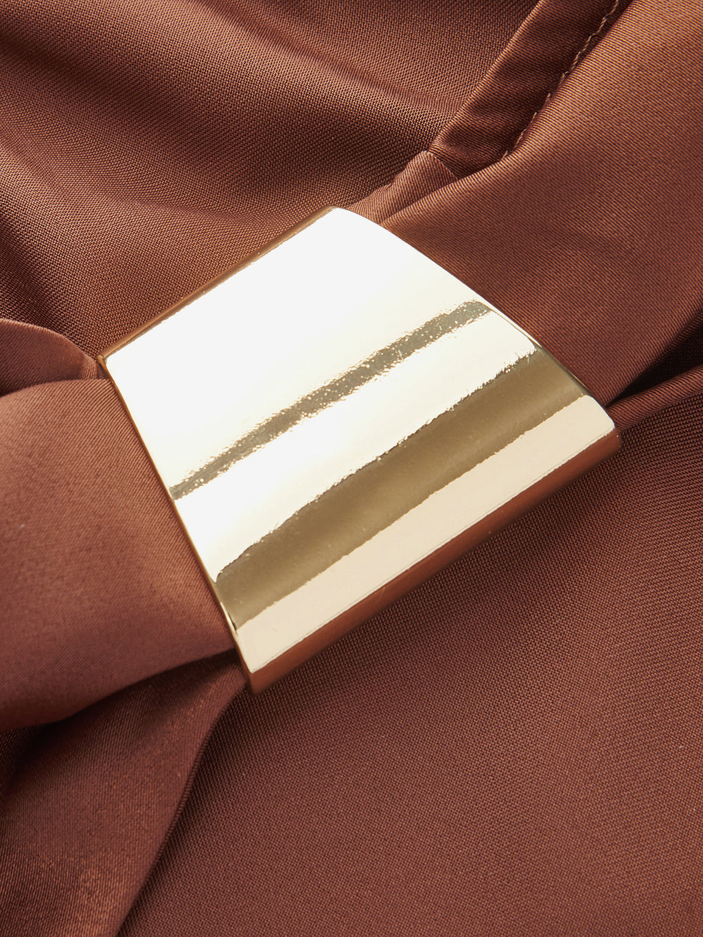 Sleeveless cowl neck satin cocktail dress with gold rectangular buckle and smooth brown fabric.