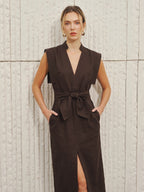 Cotton-linen V-neck sleeveless dress with bow split, front tie belt, pockets, and slit.