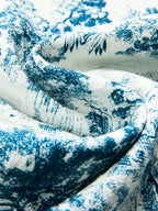 White fabric knotted crop top with blue toile pattern, delicately folded to show intricate design.