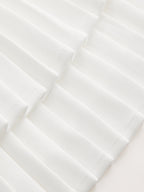 White pleated dress with crisp geometric texture and soft shadows, creating a modern look.