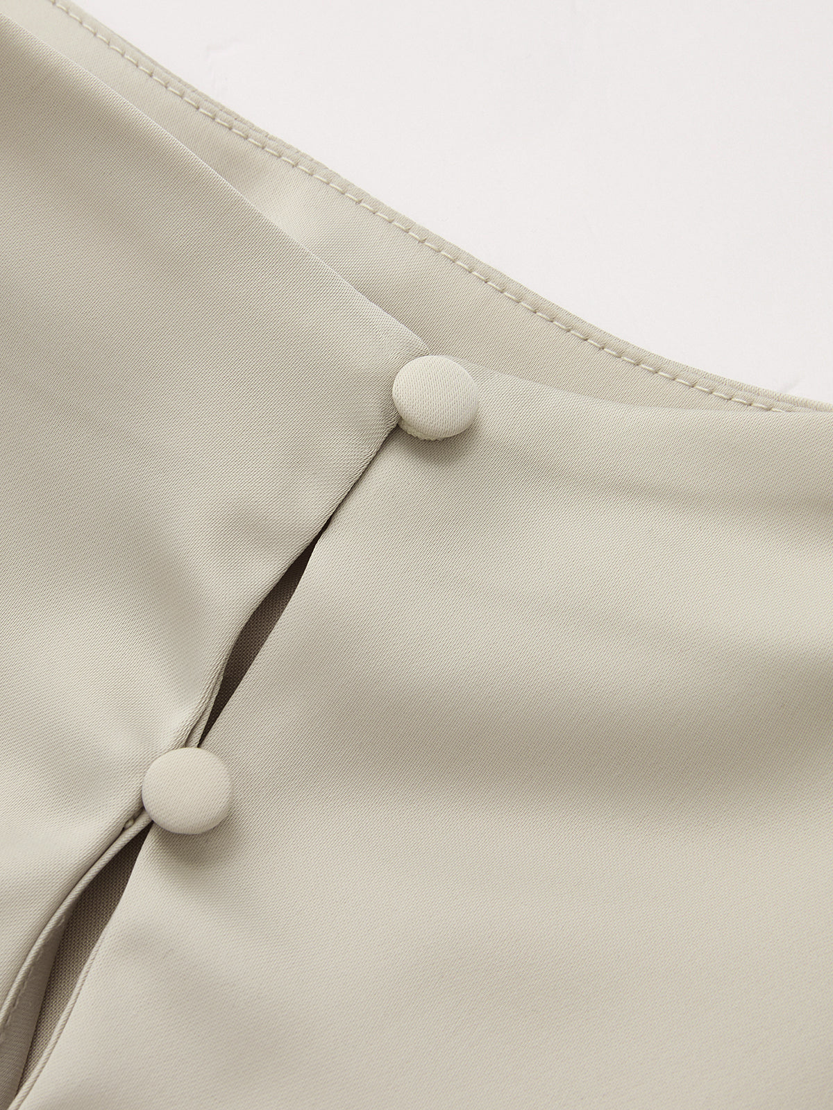 Asymmetrical satin blouse with draped ruching, cream stand collar, and two covered buttons.