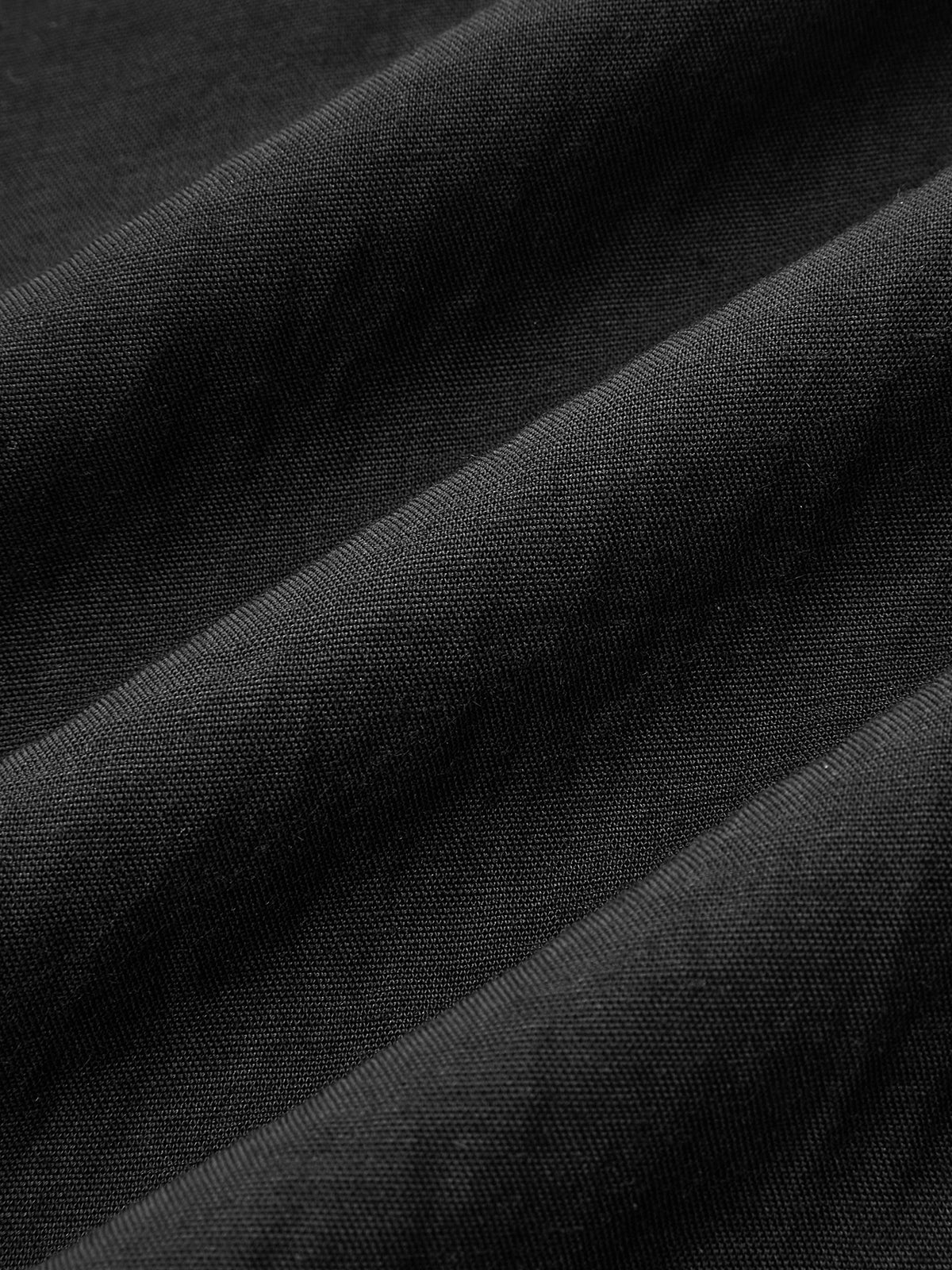Black cotton linen maxi dress with visible textured weave and softly folded halter neck.